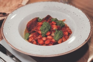 A delicious recipe of butterbean and seitan choriz-no stew topped with pesto